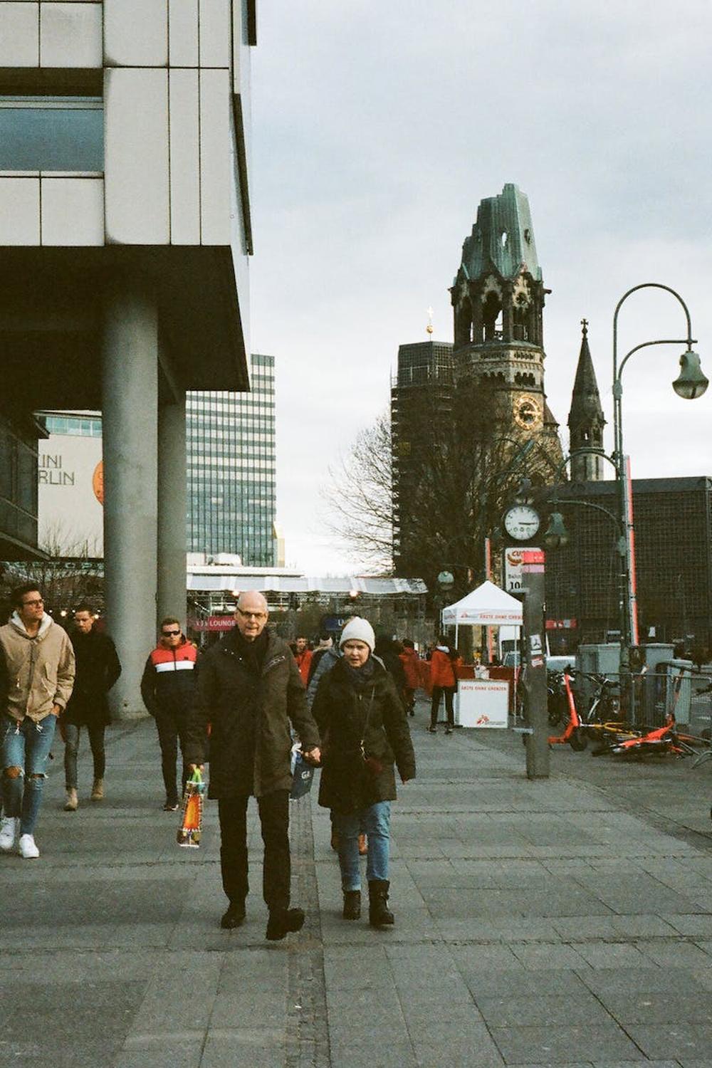 unrecognizable_pedestrians_strolling_on_sidewalk_i