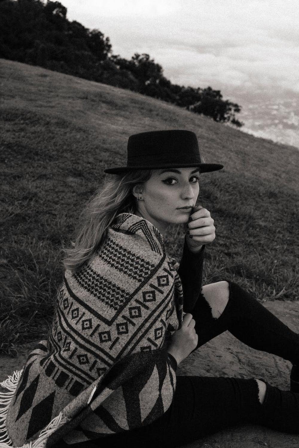 young_woman_in_hat_and_covered_with_blanket_sittin